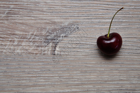 甜的木制背景上一颗红樱桃闪亮的可口图片