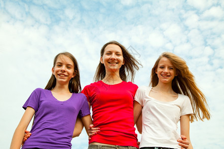 三个女孩对着蓝天欢快的青春少女积极年轻的愉快背景图片