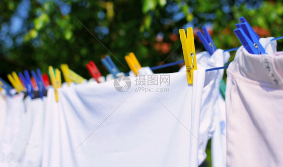 绞刑洗衣店干净的白新服挂在绳上贴着多彩的钉子图片