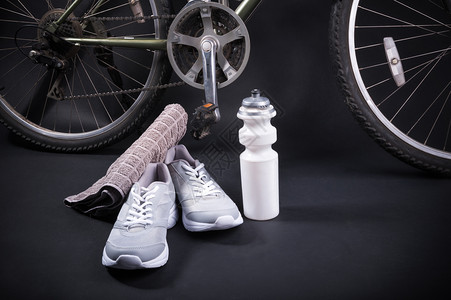 自行车配件黑色背面带运动鞋和一瓶水的自行车活动健康背景