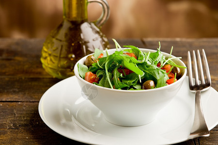 莴苣照片美味的浅色沙拉木制桌上白碗中的青菜沙拉和西红柿芝麻菜素食主义者图片