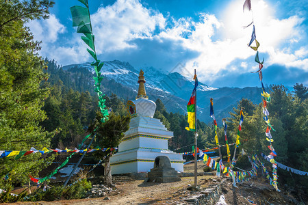 与尼泊尔喜马拉雅山和蓝天对峙的美丽白色石块佛教徒蓝的宗图片