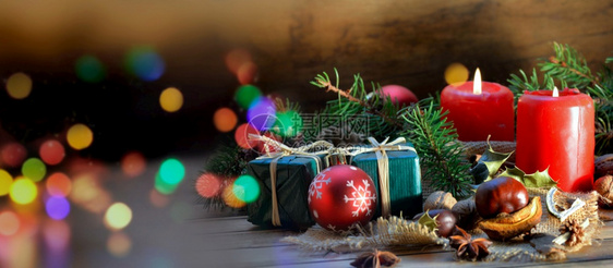 一种丰富多彩的木桌和模糊灯光上传统圣诞节装饰品蜡烛图片