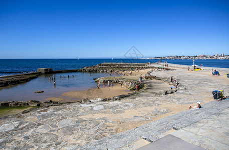 在葡萄牙埃斯托里尔的塔马斯海滩岩石上建起的受保护水池周围人们享受太阳和大西洋享受着太阳和大西洋约去海滩的人藻类图片