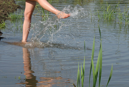 戏谑脚趾夏天女孩在湖中站立和赤脚飘荡图片