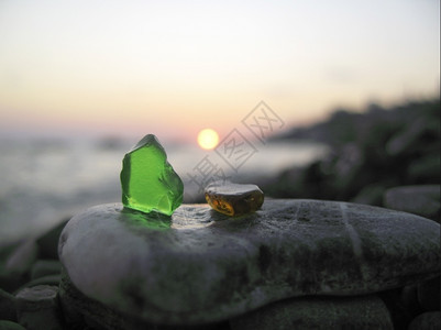 休息反射躺在海边的绿色和橙玻璃结石图片