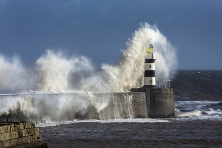沿海英格兰东北岸的汉灯塔上坠落的波浪天气码头图片