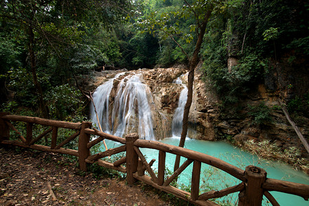美丽的瀑布绿林中含蓝水河流动风景图片