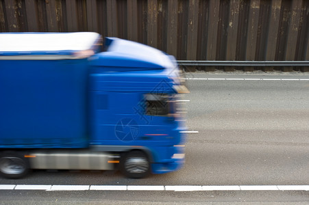 驱动器蓝色的一条多道高速公路有线和沥青蓝色卡车驶过该公路运动图片