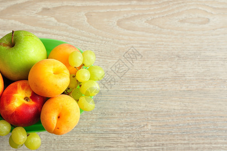 绿色塑料桶中各种水果的品植物一杏子图片