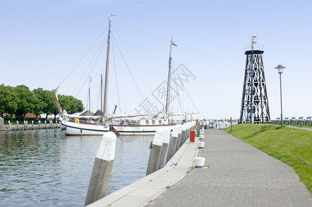 在荷兰IJsselmeer海岸的Enkhuizen港口入内一艘巨大的平底海船树木信标帆图片