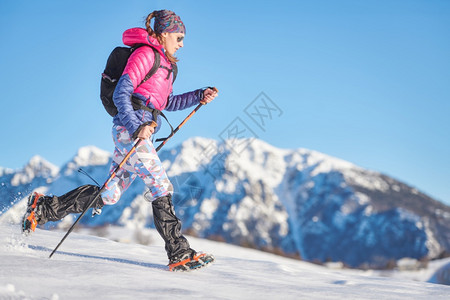 下雪的鞋女孩年青运动员在雪中抽筋和围网图片