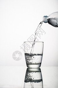 饮料从白色隔离的玻璃上溅起倒水特写从在白色背景上隔离的玻璃溅起倒水特写降低蓝色的图片