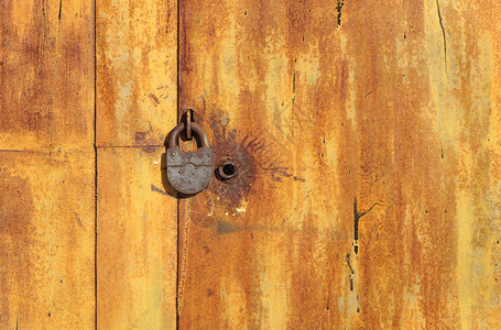 腐蚀抽象的垃圾摇滚旧生锈金属车库门和挂锁图片