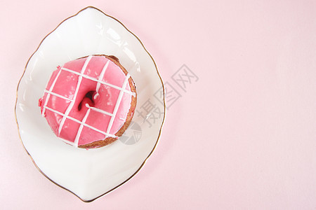 糖果粉色的白板上条纹状的明亮粉红甜圈其形式为叶子金涂在粉红色背景空间上陶瓷图片