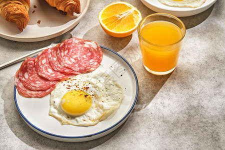 煎鸡蛋和香肠配羊角面包和橙汁图片
