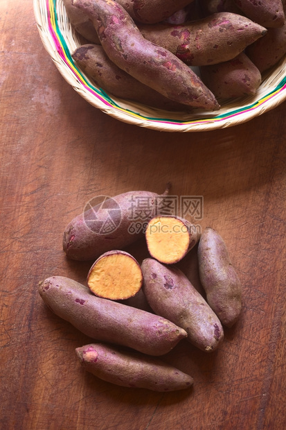 巴塔斯块状木板上用自然光照的生紫色甜土豆头片IpomoeaBatatas营养图片