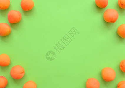 夏天绿背景的杏子排列在角落框中带复制空间顶视图关闭绿色背景的水果架子在角上安排复制空间顶视图关闭面板最佳黄色的图片