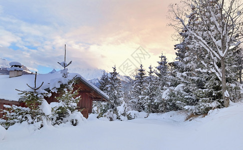 木制的在清雪中木制高山小屋上美景在日落的木制高山小屋上在日落的鲜雪上在日落时有毛树新鲜的风景优美图片