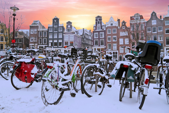 街道老的建造日落时荷兰阿姆斯特丹的雪地自行车图片