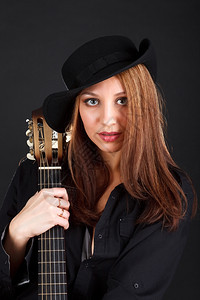 成人一个年轻有魅力的女人肖像带着黑色背景的吉他一种女士图片