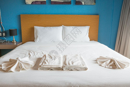 酒店家具旅行白枕头和睡在房间里的白床上图片