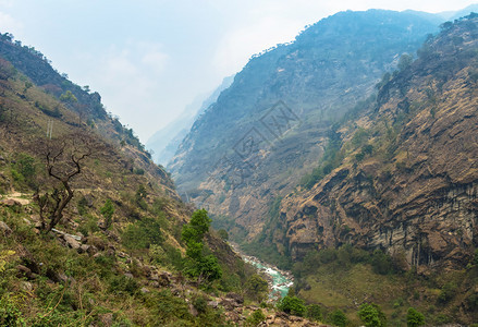 美丽区徒步旅行尼泊尔喜马拉雅山春日的深峡谷图片