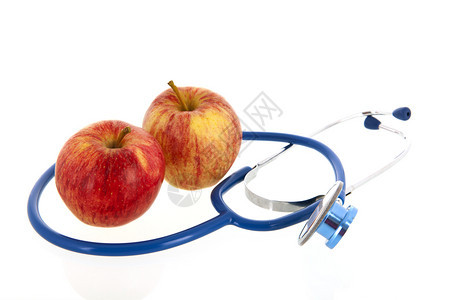 控制工作室白底隔离的红苹果和医疗听诊器用于保健护理测量图片