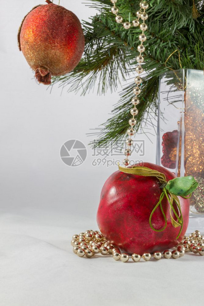 圣诞树枝和花瓶中的装饰包括人工石榴和苹果以及绿色装饰风格假期图片