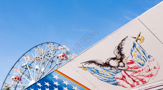 条纹旗帜接触美国的符号在背景中飞轮和天空是摩之轮图片