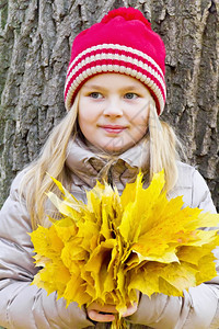 小女孩手捧秋叶花束图片