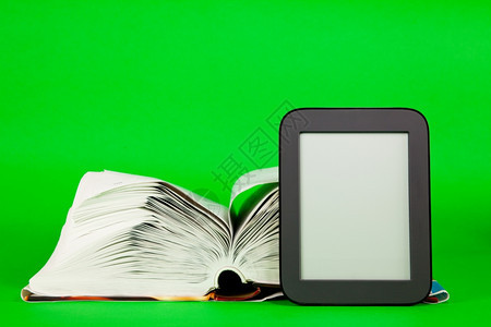 图书馆当代的文学打开书和电子阅读器反对绿色背景图片