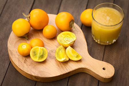 Naranjilla或Lulo果实latSolanum在木板上脱脂边配有新鲜的naranjilla果汁选择焦点关注前面被切开的玉图片