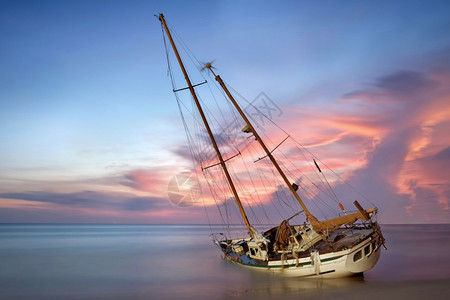 航行日落时沙滩上的帆船、图片