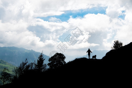 步行水人和他的狗在山上行走人们图片