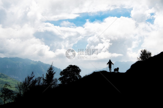 步行水人和他的狗在山上行走人们图片