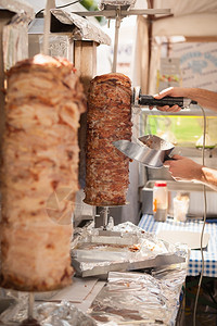 街道羊肉烧烤厨师用电刀割切烤肉串的手烤肉串是土耳其的典型菜盘图片