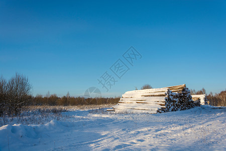 自然桩大堆雪覆盖了路边的木头在明晴冬季白天清除图片