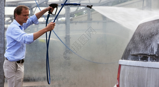 软管单身的车辆男子用高压喷雾在洗车时用肥皂图片