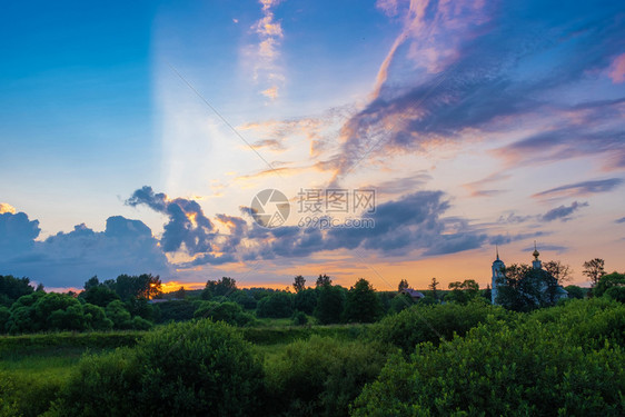 美观的明云全景在日落的光芒中和白教堂的钟塔俄罗斯橙夏天蓝色的图片