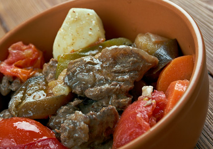 传统的薯条Chanakhi格鲁吉亚传统炖羊肉菜土豆绿菜和大蒜配有西红柿黄豆青菜和大蒜午餐图片