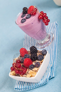 一杯新鲜的美味酸奶加浆果和穆埃西里薄片玻璃美味的图片