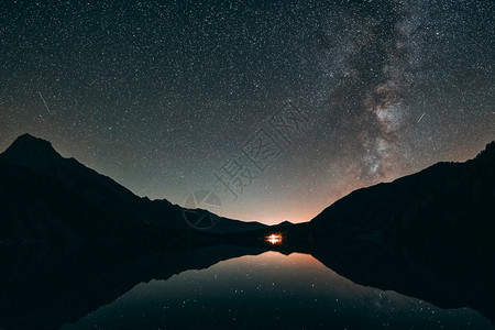 山区和平静水体的太阳光照股票繁星点座背景图片