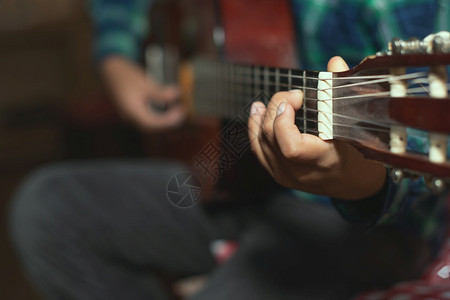 吉他手居住创建小孩在左单体的手指上弹古典吉他细节产生和弦图片