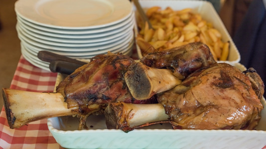 小腿在意大利餐厅烤炉里用土豆小牛肉的中点用餐传统图片