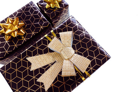 三个黑色礼品盒带有几何图案和金弓在白色背景上隔开文字空间假期卡片生日图片