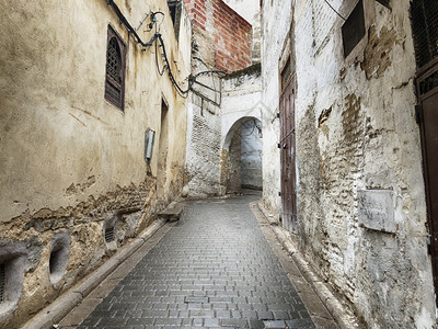 墙壁人们非洲摩洛哥FezMedina旧城的一条狭小街道穿过山坡一个拱门图片
