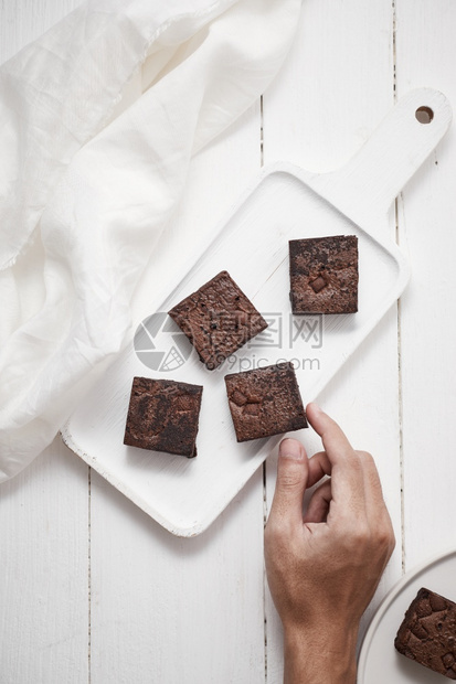 一块自制巧克力布朗尼甜点和一种蛋糕糖图片