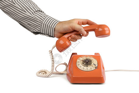 手机目的讲话男用手举起老式电话听筒在白色上隔离图片