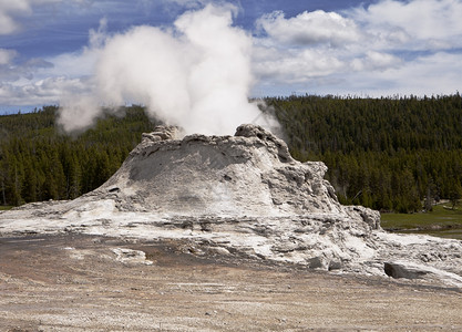 发泄的一种Geyser城堡是黄石公园中最大的火山喷嘴之一黄石公园在多年爆发后形成一个大锥体这观点显示蒸汽从顶层喷口升起图片